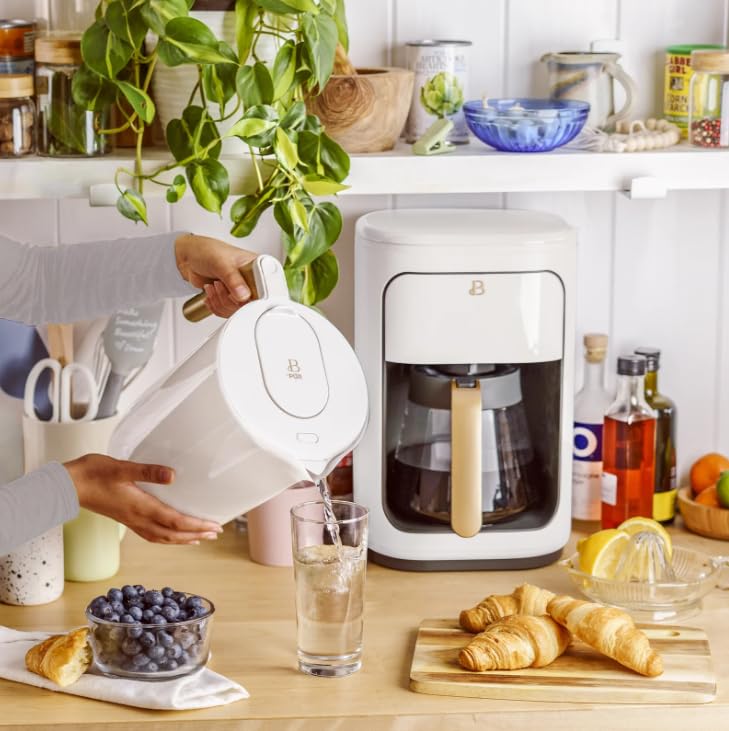 Person pouring water from the Beautiful by PUR pitcher into a glass