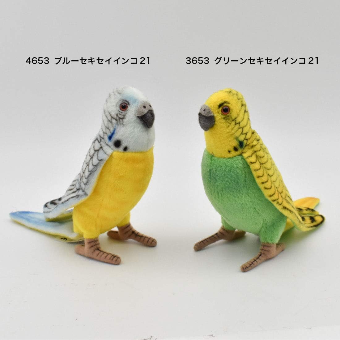Hansa Plush Budgerigar (green/yellow) next to a blue Hansa plush budgerigar