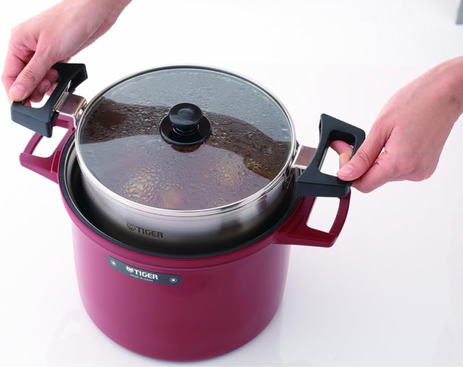 A person carefully placing the inner pot with a glass lid into the red outer thermal container of the slow cooker.