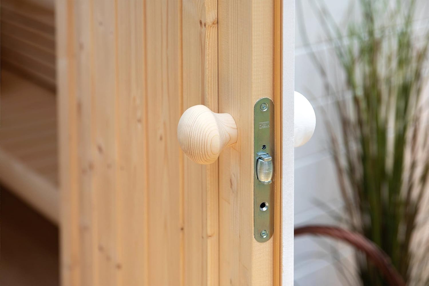 Close-up of the wooden door handle and latch mechanism of the Polhus Jorma sauna door.
