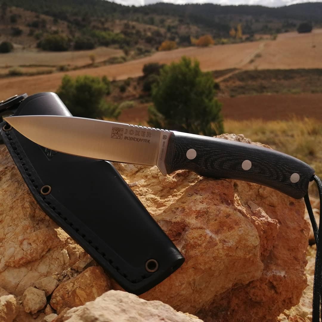 Joker Bushcraft Bushcrafter Nóż survivalowy CM120, czarna skórzana osłona, ostrze 10,5 cm ze stali Böhler N695, czarny uchwyt Micarta, narzędzie do wędkowania, polowania, biwakowania i wędrówek