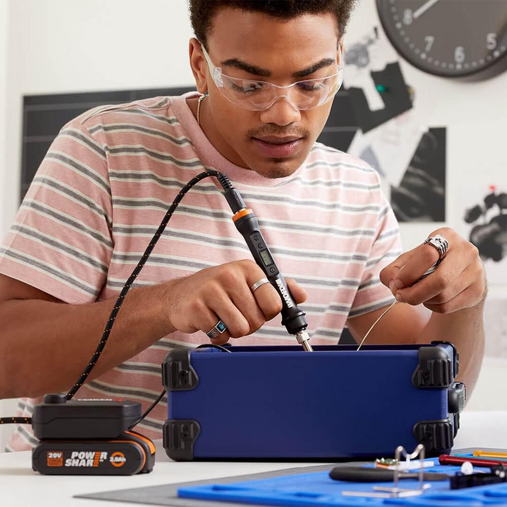 Hand using a rotary cutter tool powered by the Control HUB to cut fabric