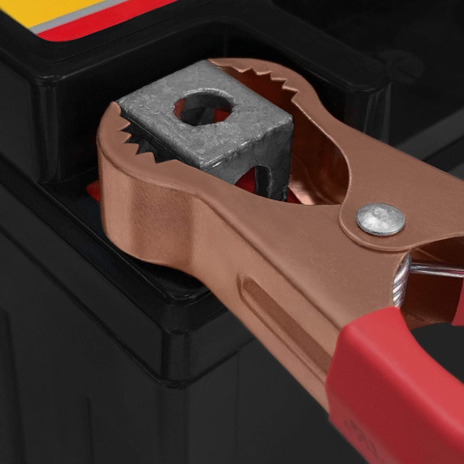 Close-up of red alligator clip connected to a battery terminal