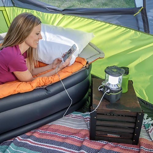 Woman charging a smartphone with the CORE lantern inside a tent