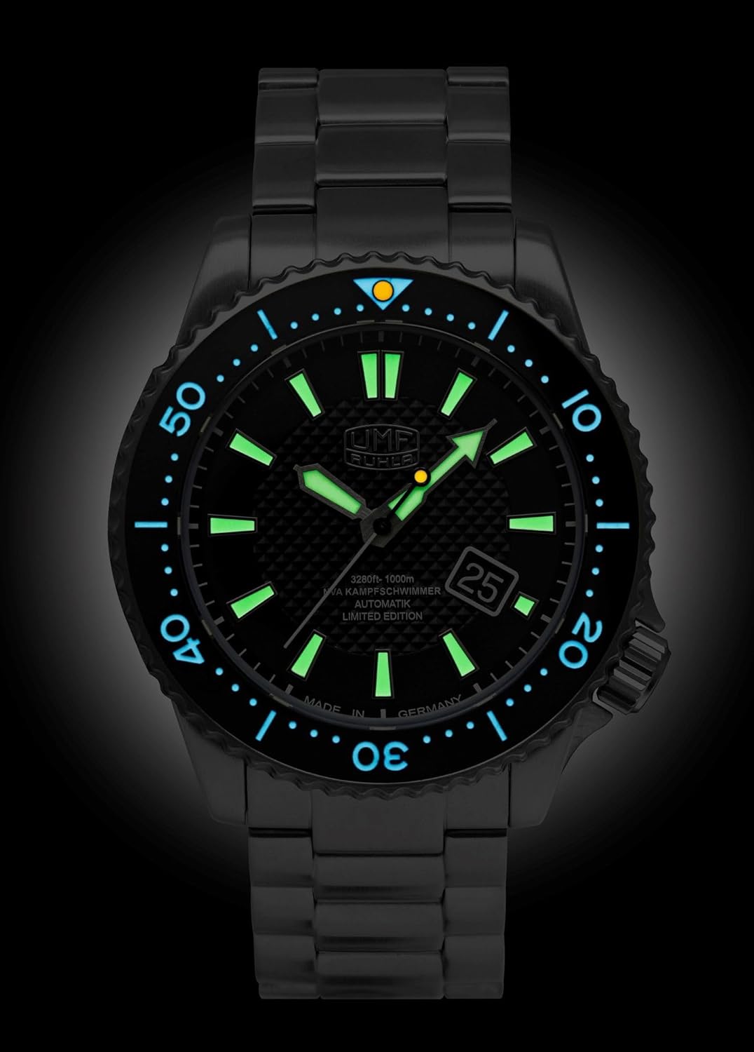 The UMF RUHLA NVA 1952-M2 watch in darkness, showing the bright green luminous indices and hands, and the light blue luminous bezel marker.