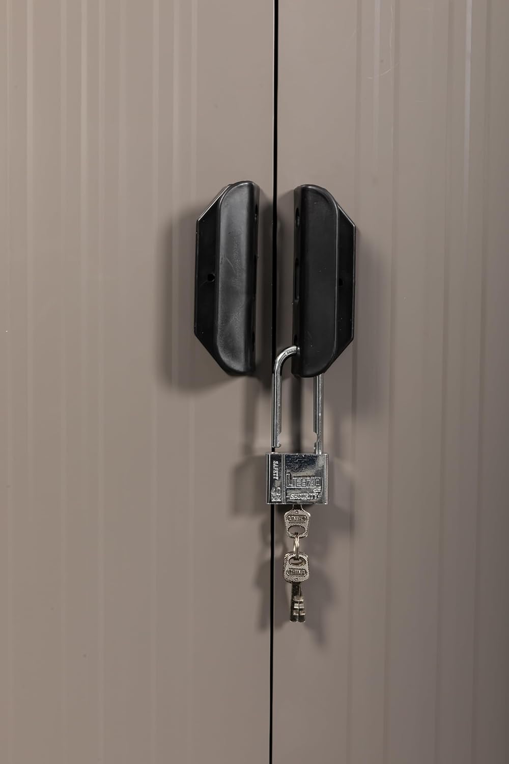 Close-up of the shed's lockable sliding door mechanism with a padlock.