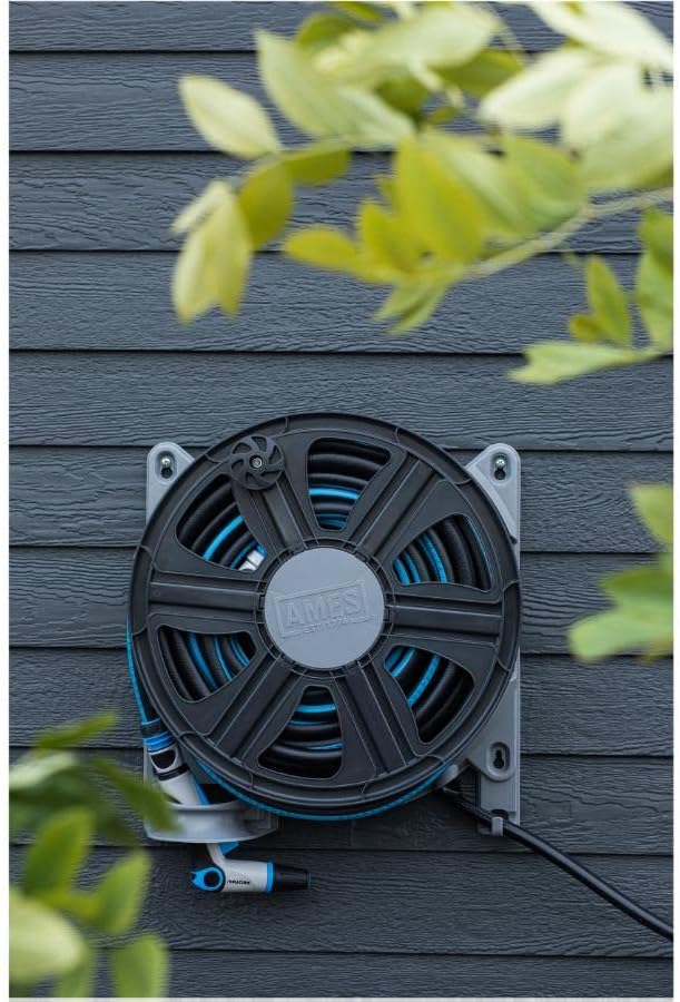PRO FLOW hose reel mounted on a dark grey exterior wall with a garden hose wound around it.