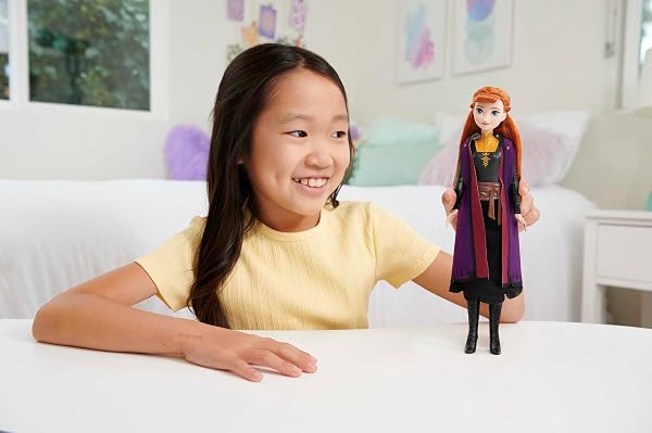Gros plan sur la poupée Anna de Mattel, montrant sa tenue de voyage et ses accessoires amovibles.