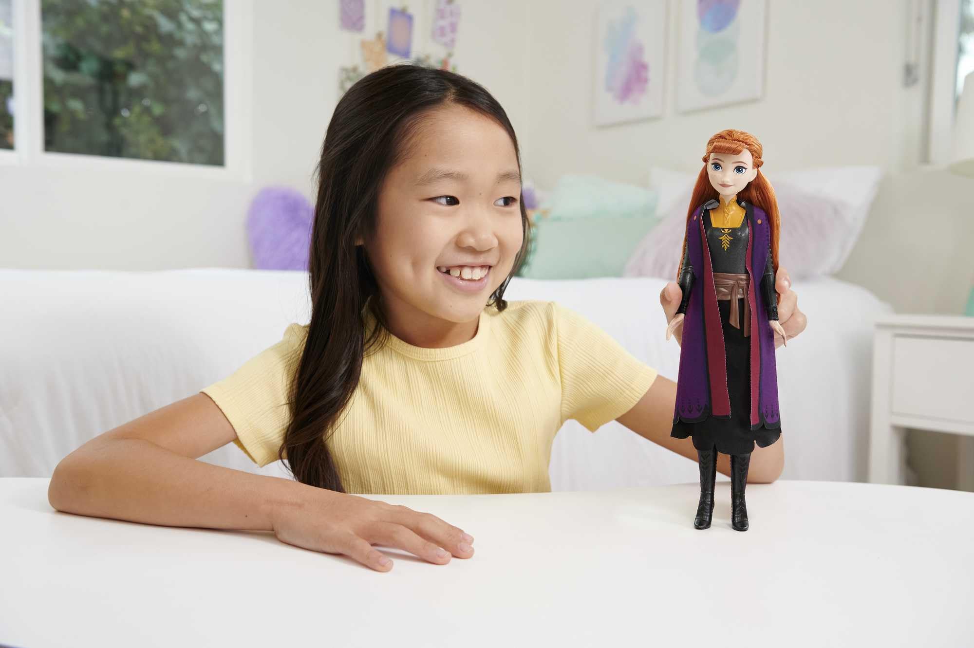 Gros plan sur la poupée Anna de Mattel, montrant sa tenue de voyage et ses accessoires amovibles.