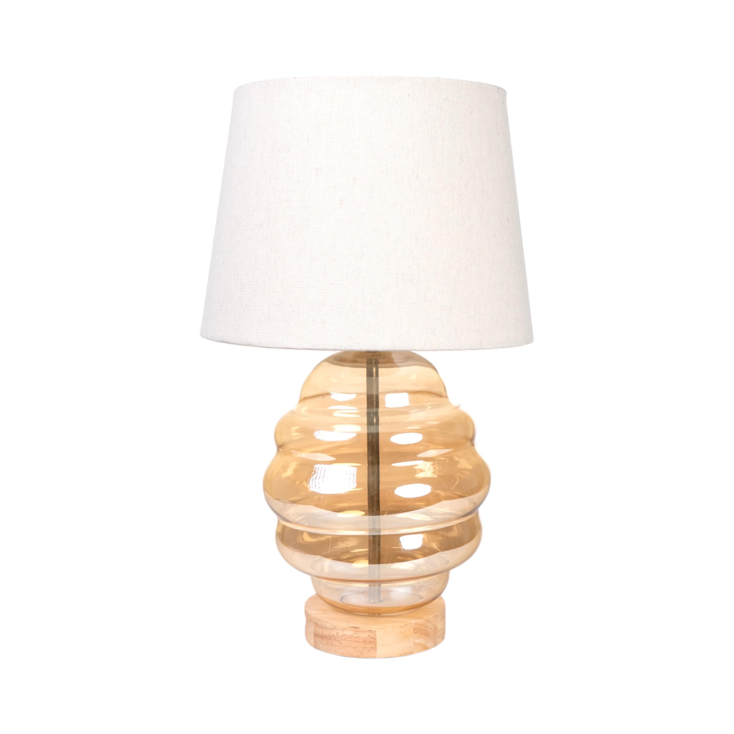 Lampe en verre beige crée une ambiance cocooning sur la table de chevet