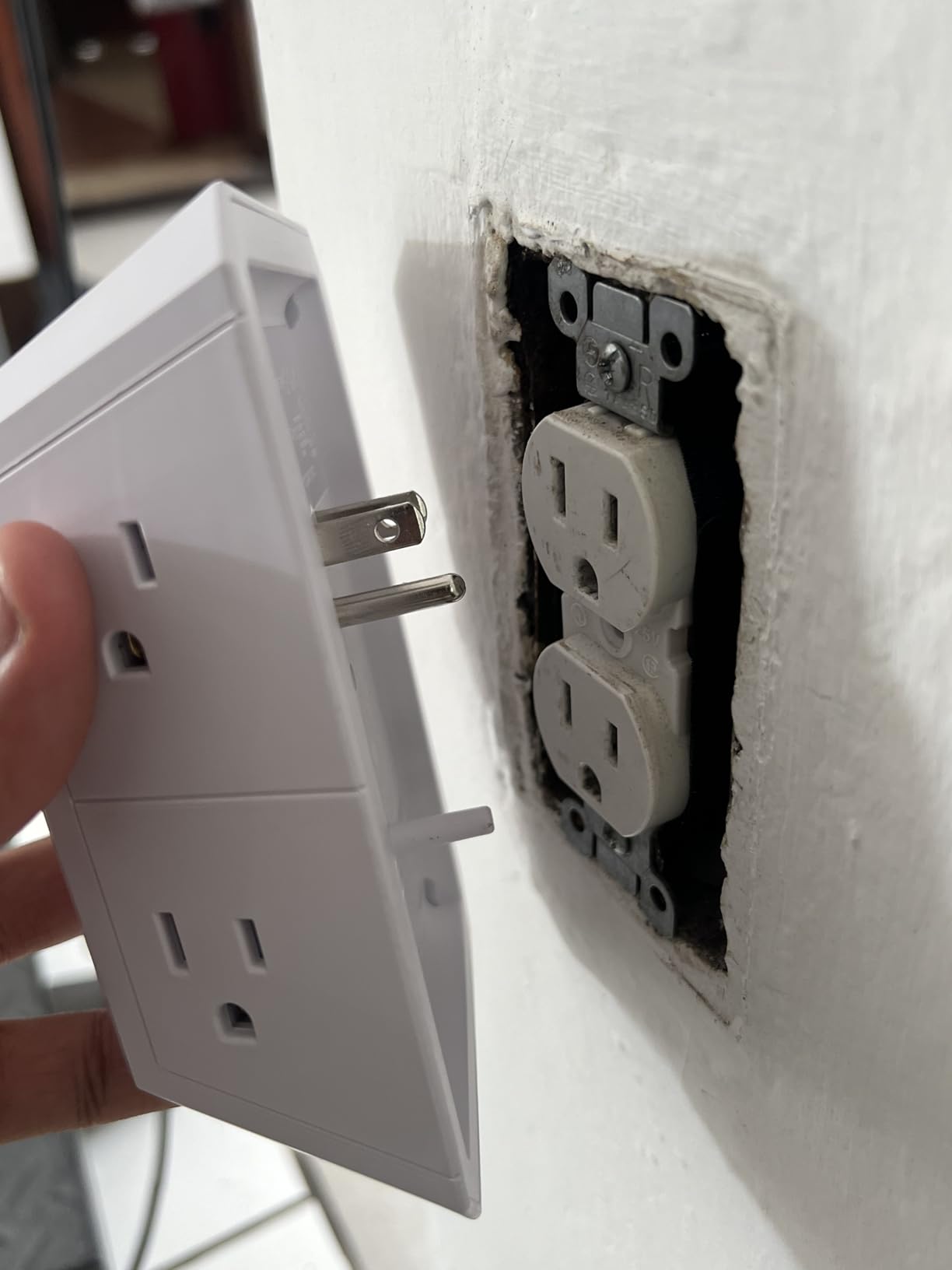 QINLIANF outlet extender being installed on wall outlet