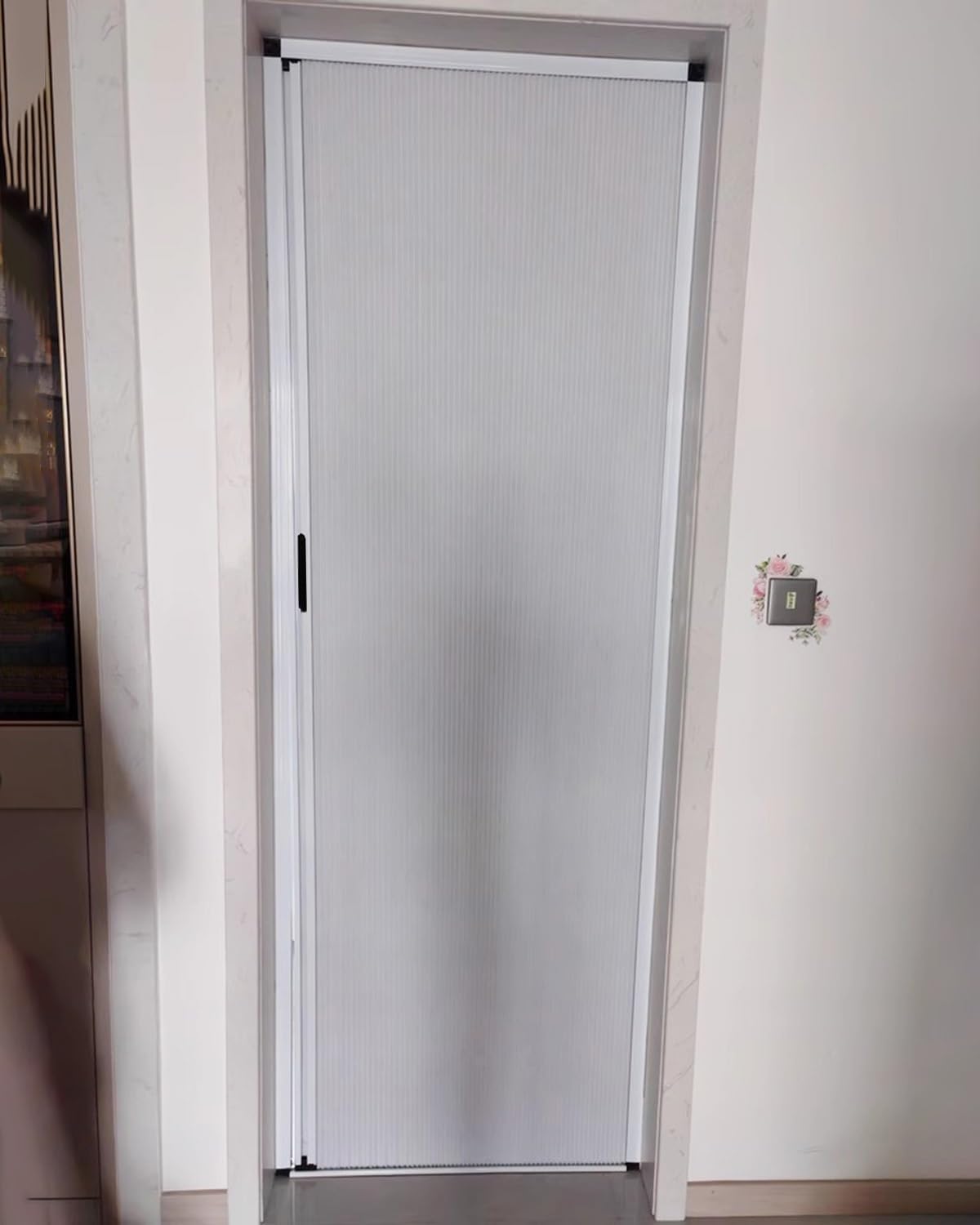 Porte pliante coulissante blanche avec serrure pour diviser un salon