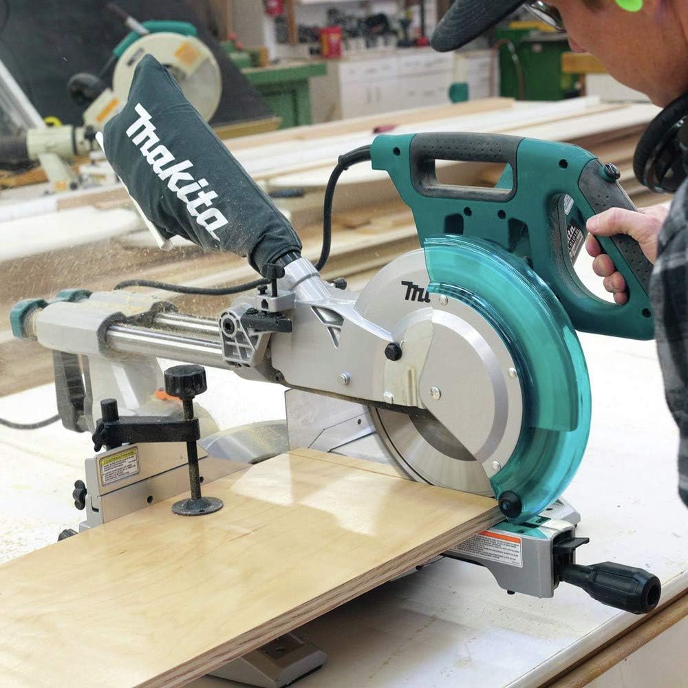 User operating the Makita LS1018 miter saw to cut a wooden board