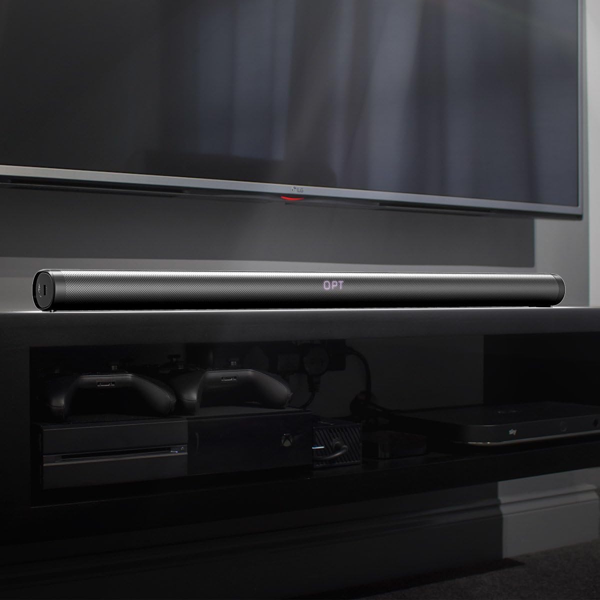 Joly Joy Soundbar placed on a TV stand under a television