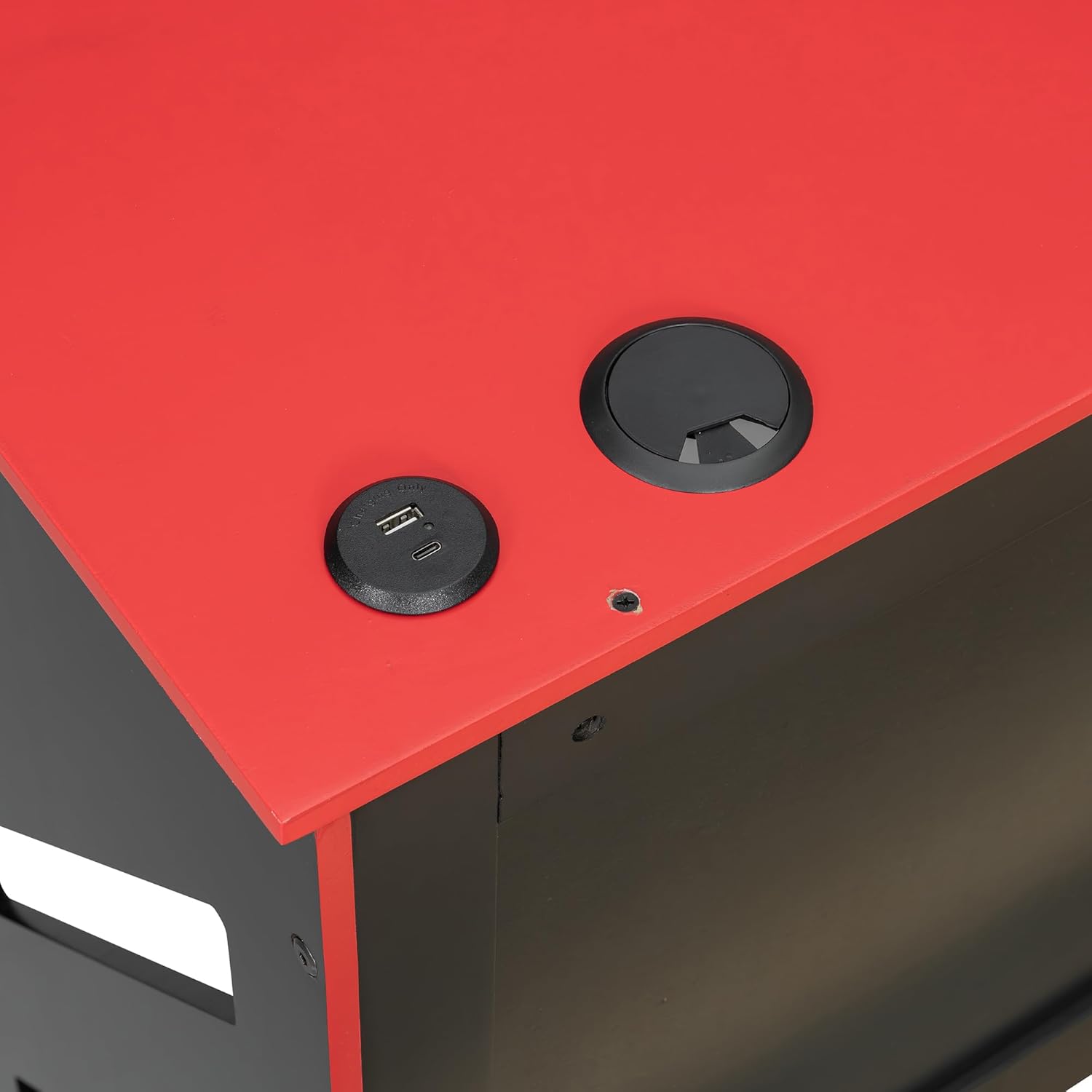Close-up of the USB charging ports and cable management grommet on the desk surface.