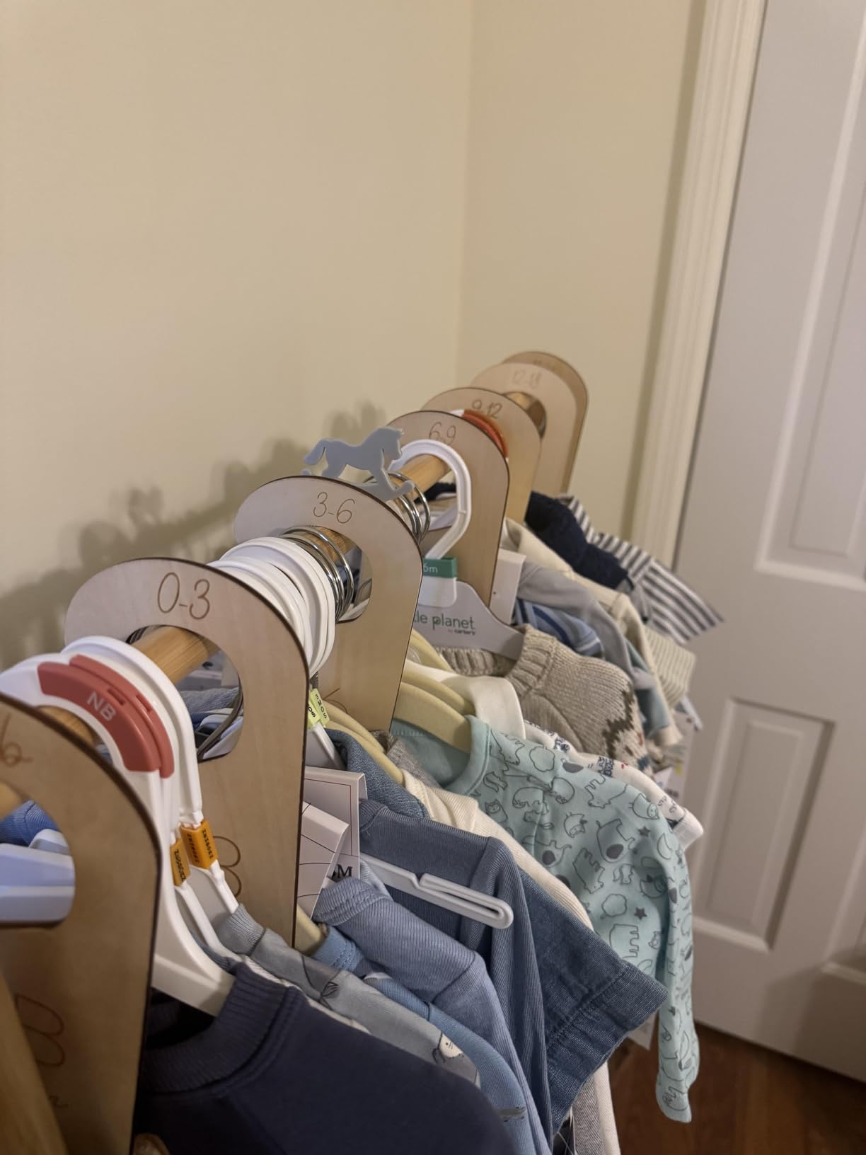 Baby closet organized by clothing size with dividers