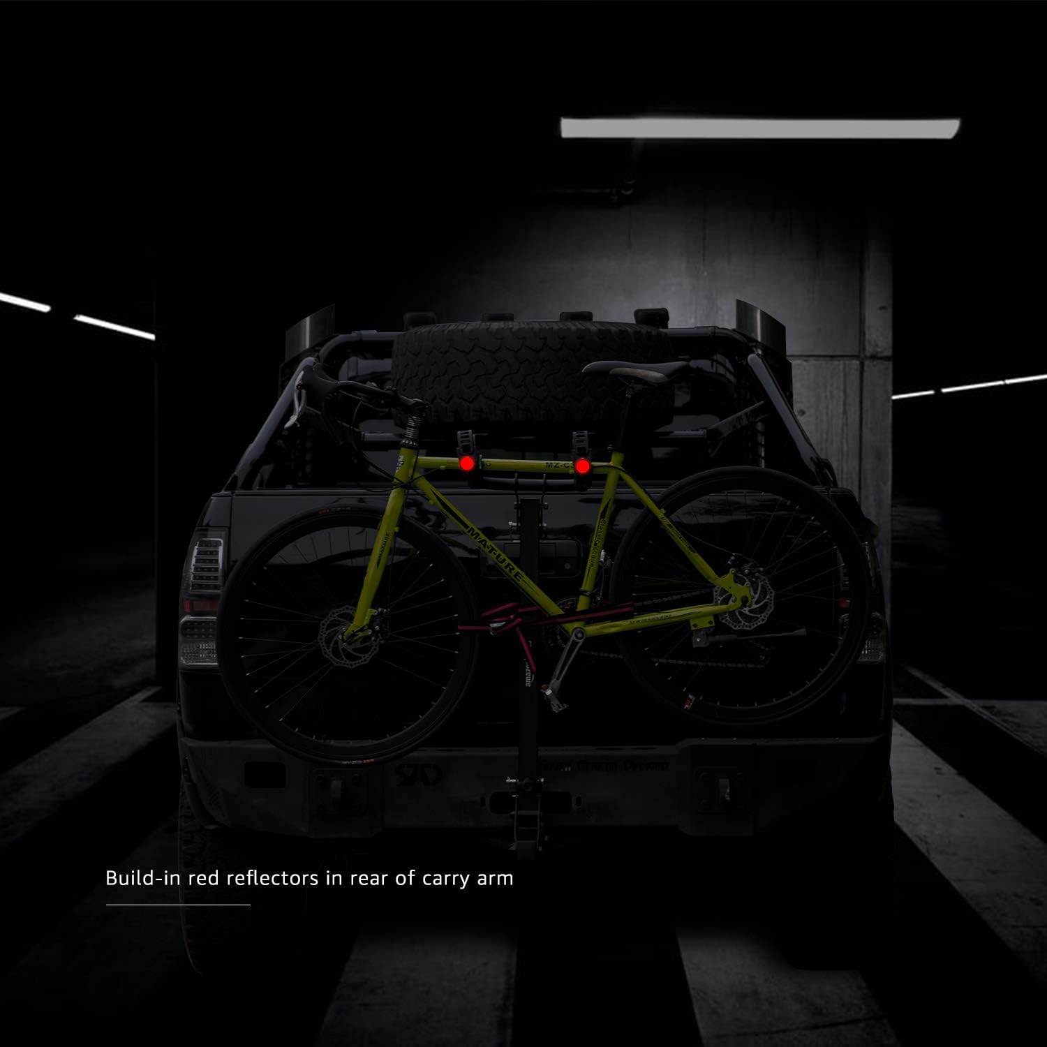 A close-up of the bike rack's carry arm in a dark setting, highlighting the built-in red reflectors for visibility.