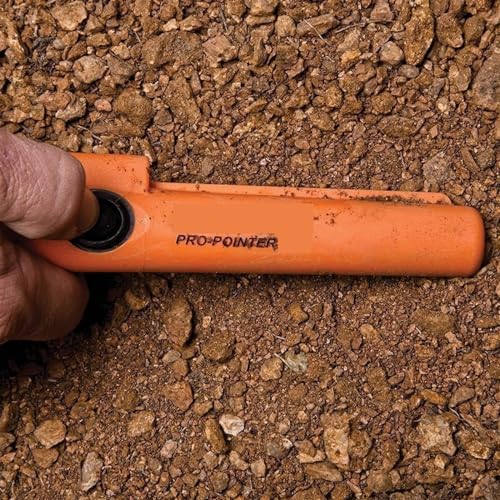 Détecteur de métaux à main orange pour localiser une pièce d'or perdue