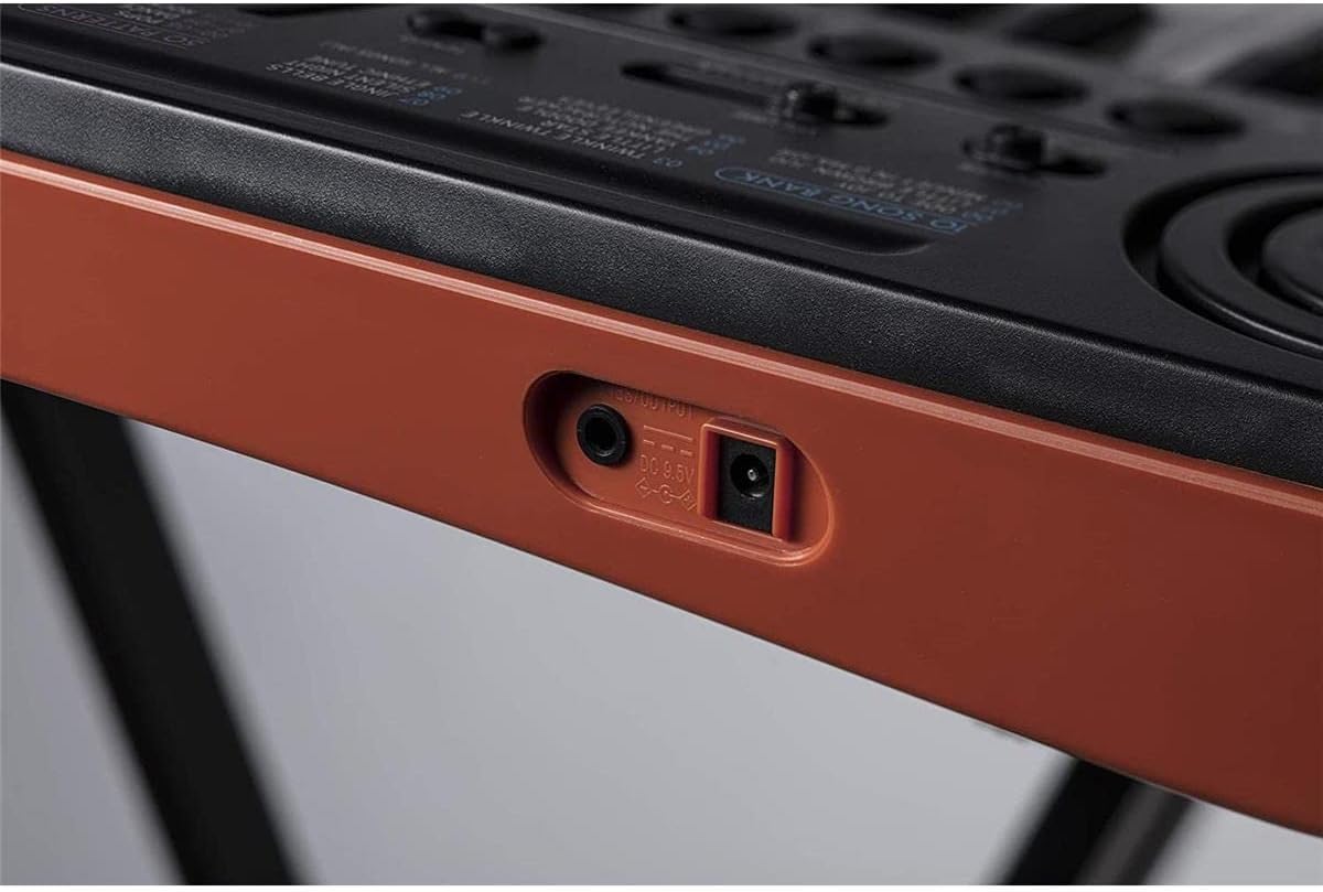 Close-up of the headphone and power input jacks on the side of the Casio SA-76 keyboard.