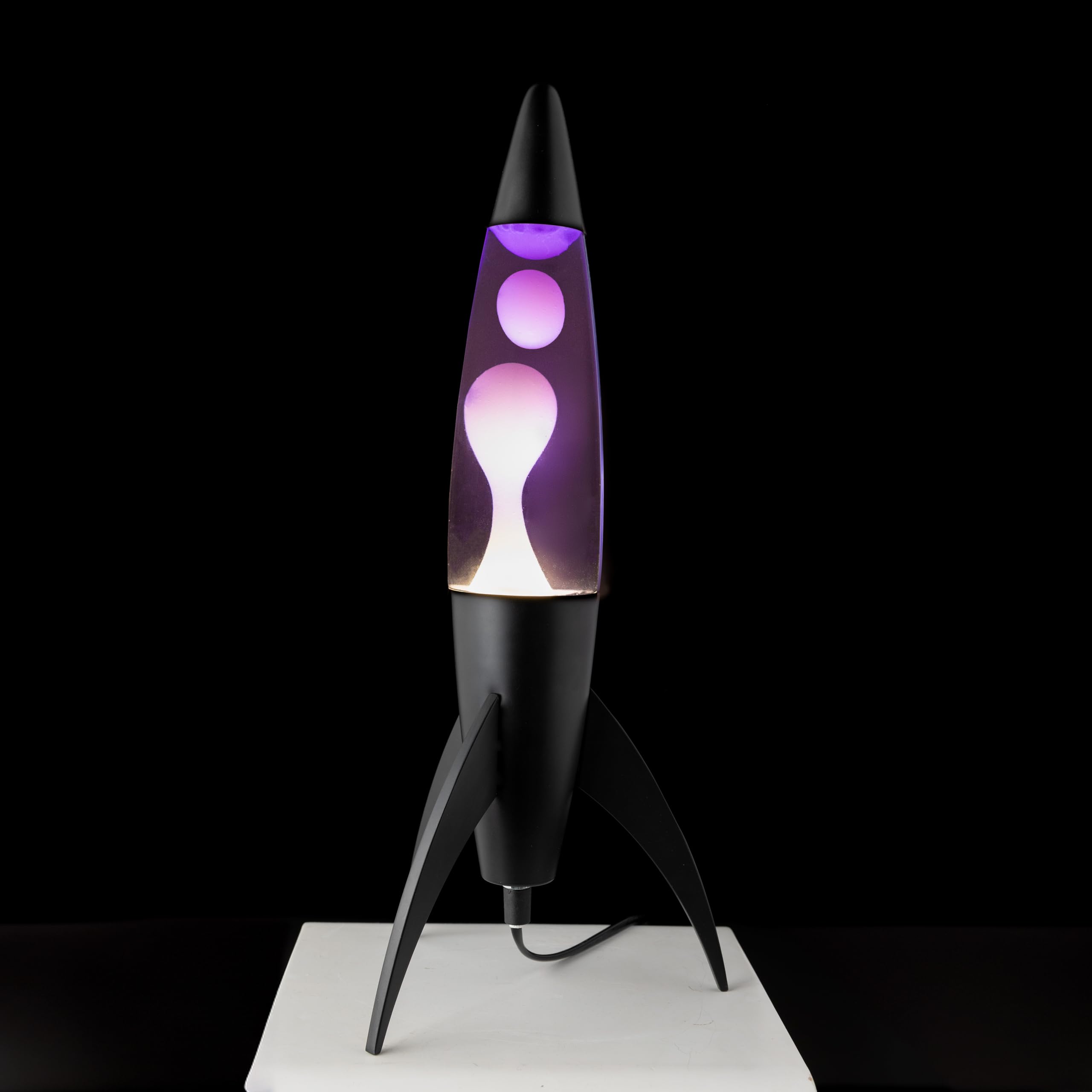 Fisura - Fioletowa lampa lawowa "Rocket". Czarna podstawa, fioletowa ciecz i biała lawa. Lampa lawowa retro z zapasową żarówką. Idealna do salonu, biura lub sypialni. Wymiary: 20 cm x 20 cm x 45 cm.