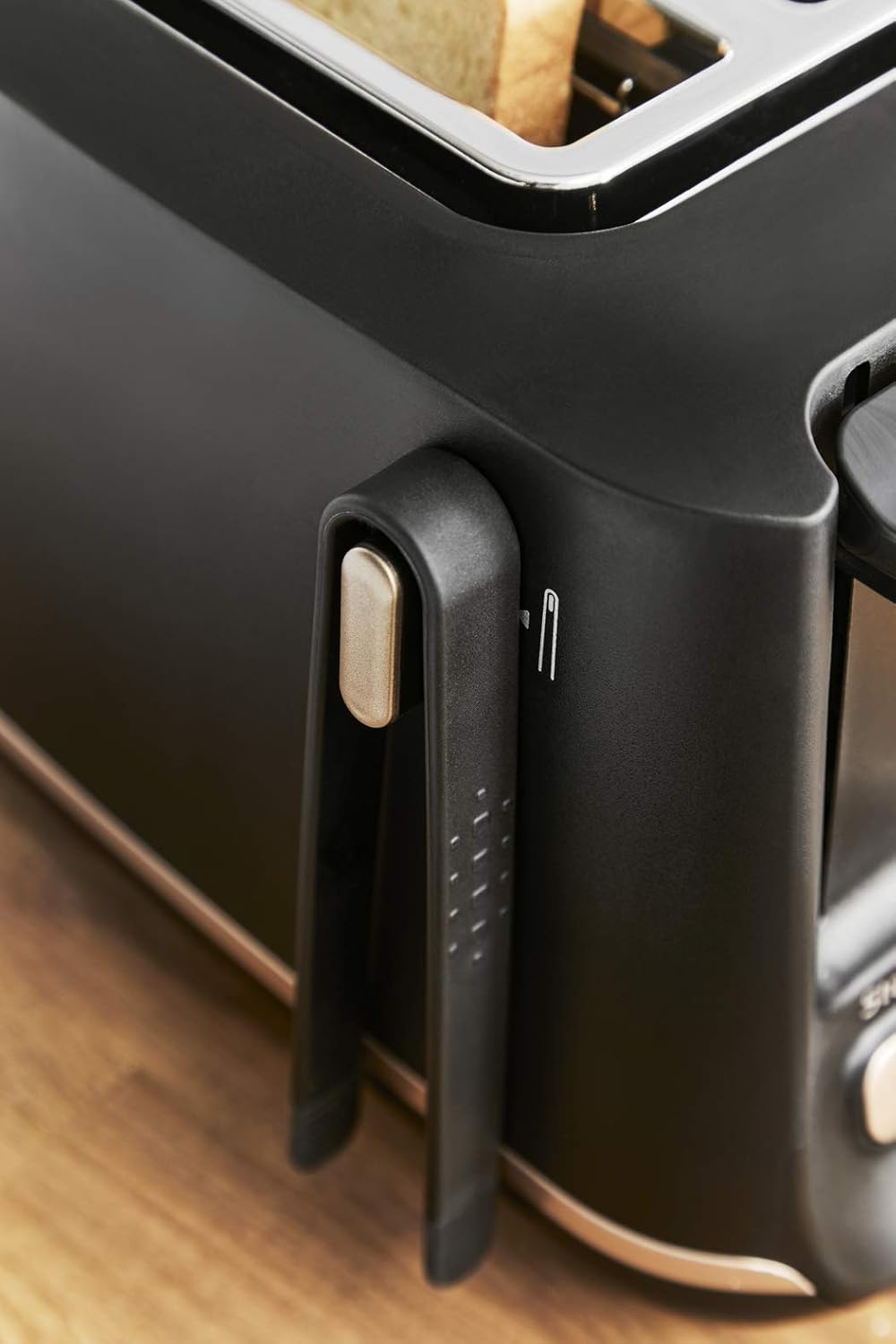 Side view of the Tefal Includeo toaster showing the magnetic toast tongs conveniently attached to the side.