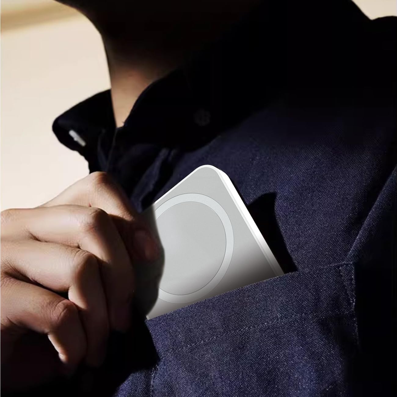 Dudao K26 Power Bank being placed into a shirt pocket, highlighting its compact and portable design.