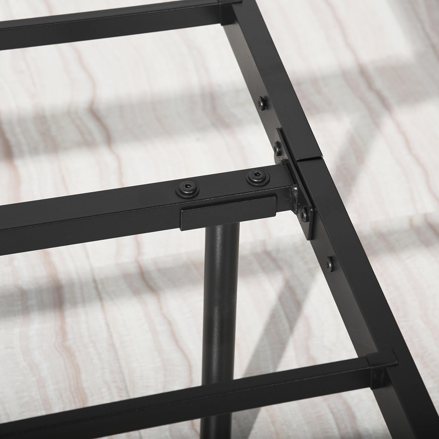 Close-up view of a metal bed frame corner connection with bolts.