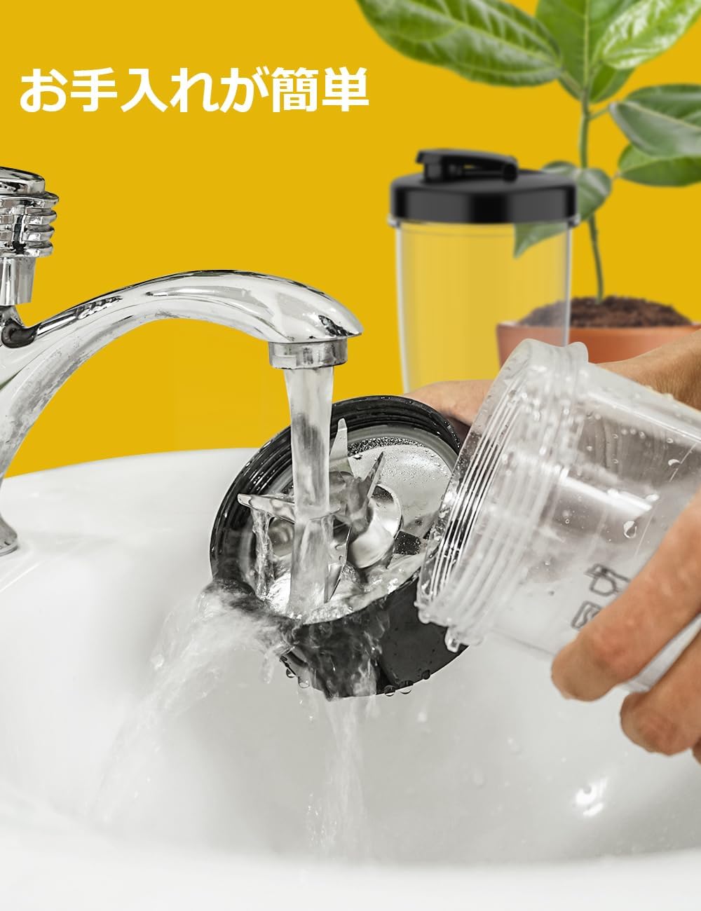 A hand rinsing the blade assembly and cup under running water in a sink.