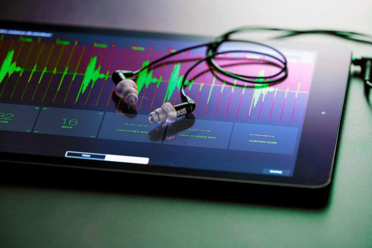 Etymotic ER3XR earphones resting on a tablet displaying audio waveforms.