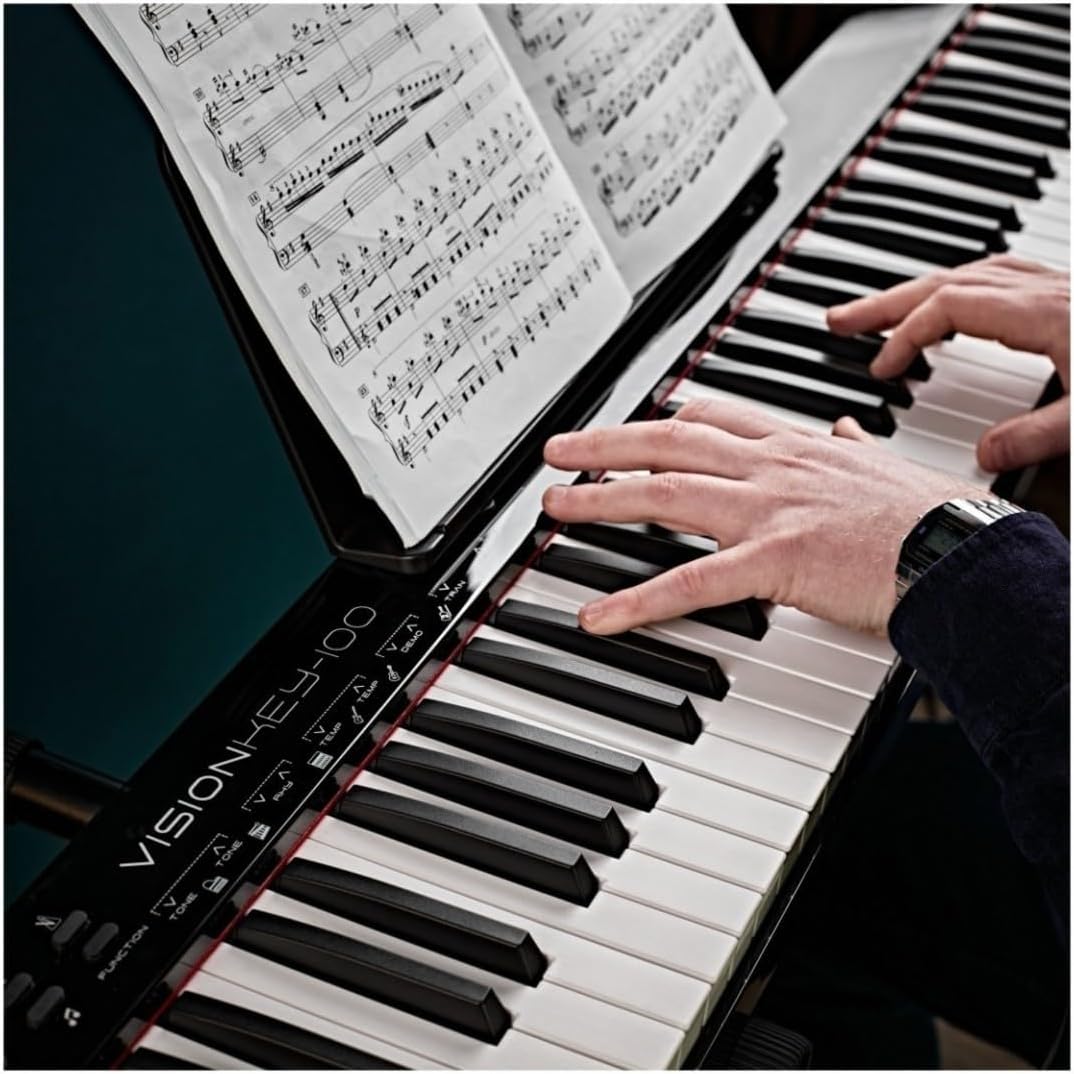 Person playing the VISIONKEY-100 Digital Piano with sheet music on a tablet