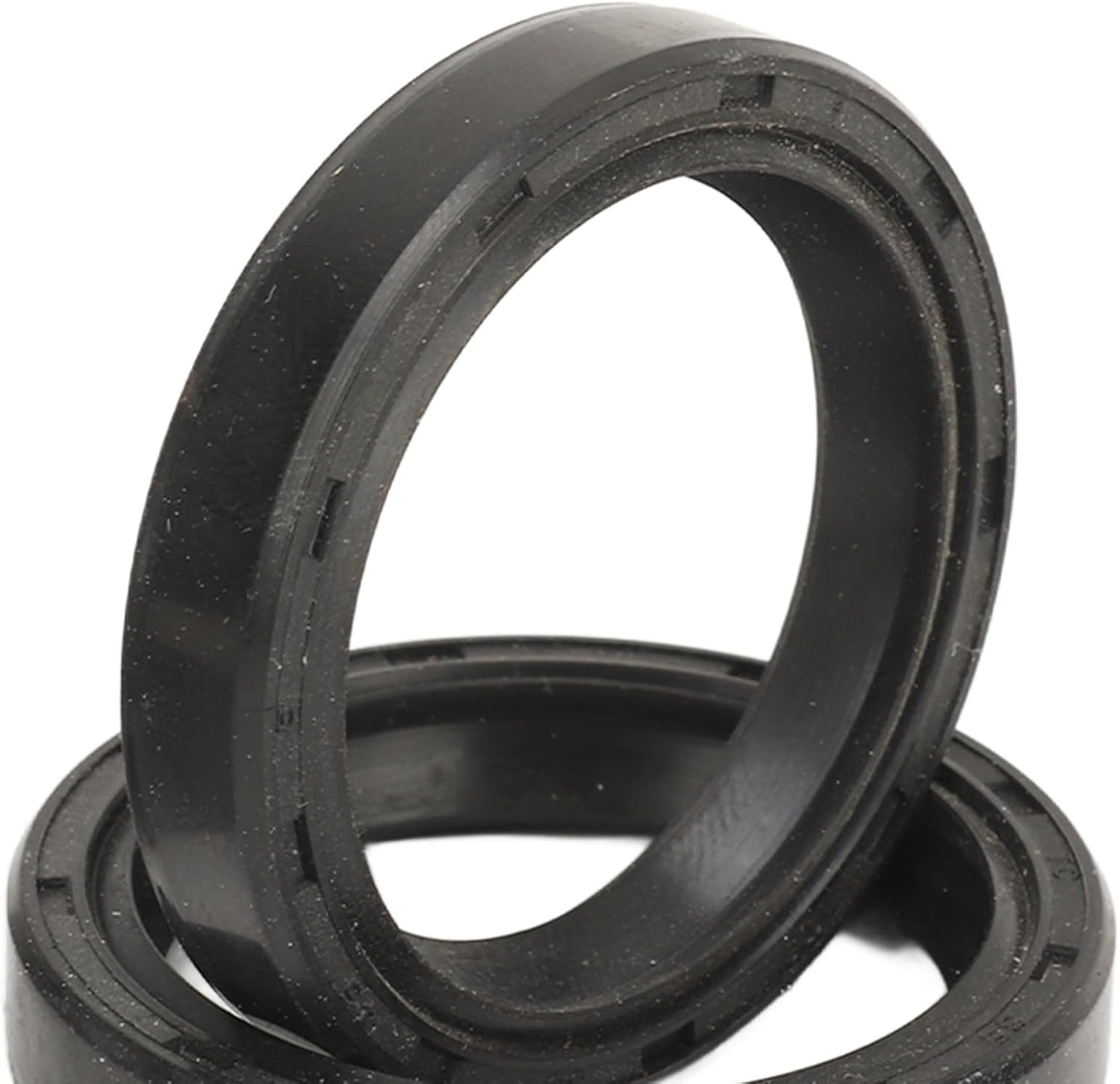 Close-up view of two new black rubber oil seals