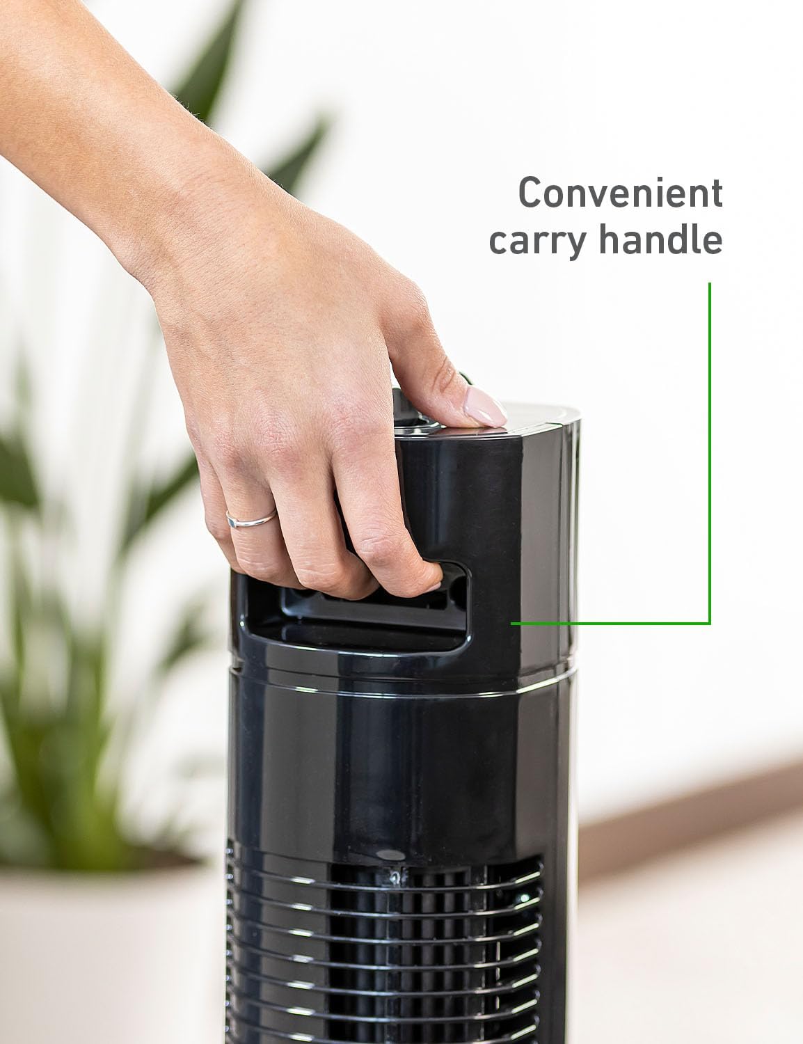 Hand using the integrated carry handle on top of the Holmes tower fan