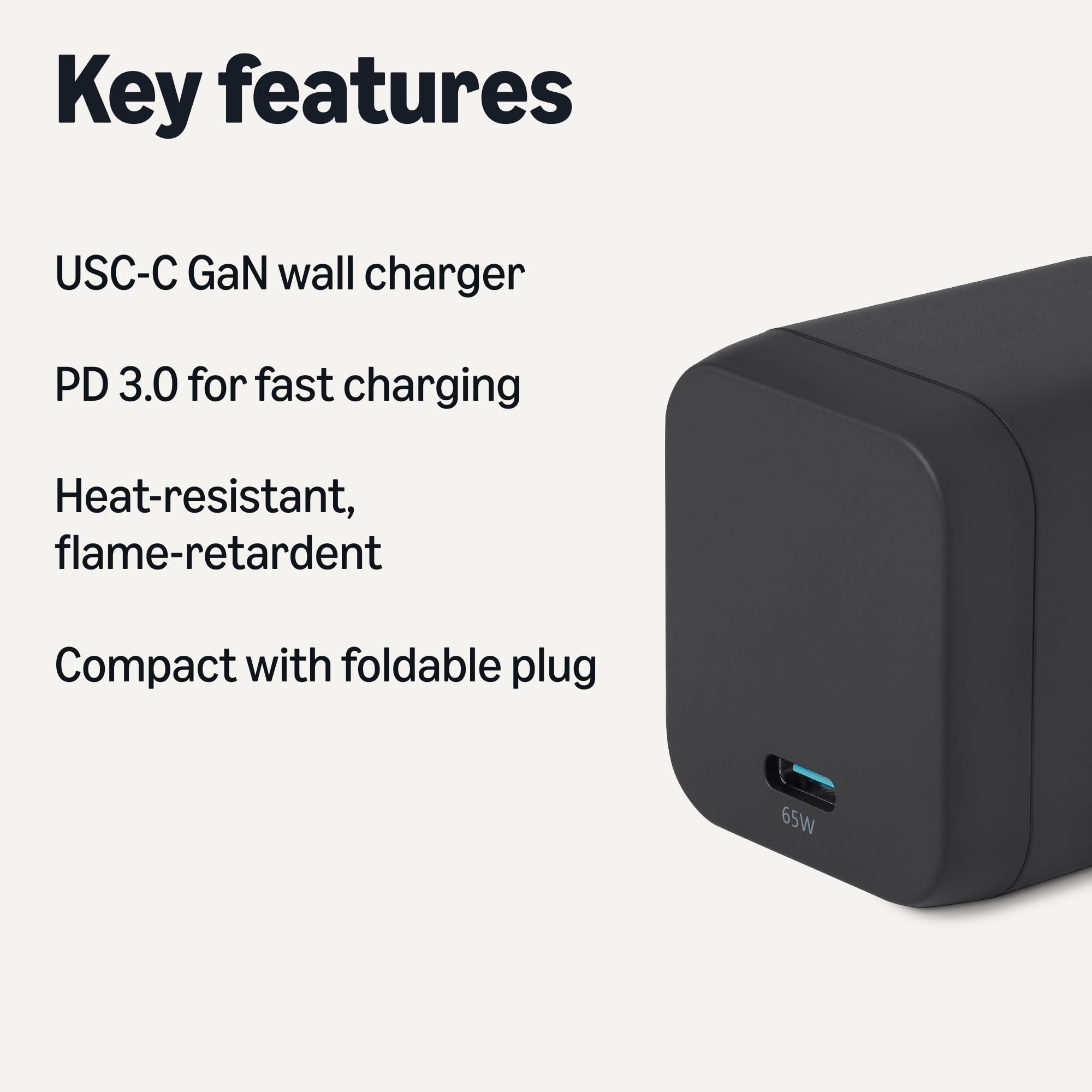 The compact, black Amazon Basics 65W GaN charger with its foldable plug extended.
