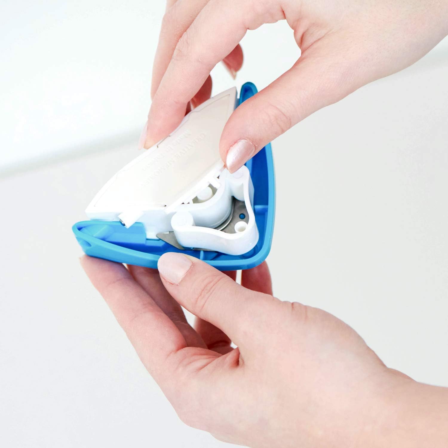 Hands opening the scrap catcher compartment on the bottom of the corner rounder