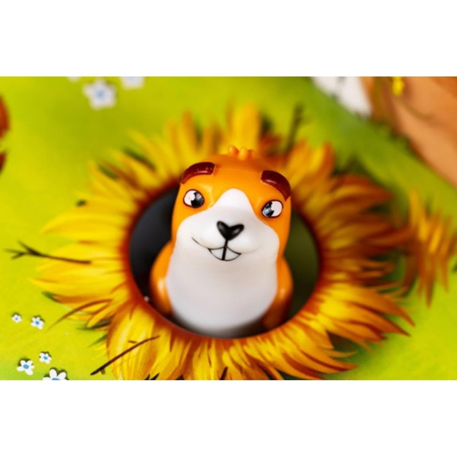 Close-up of a prairie dog game piece emerging from a sunflower hole on the game board.