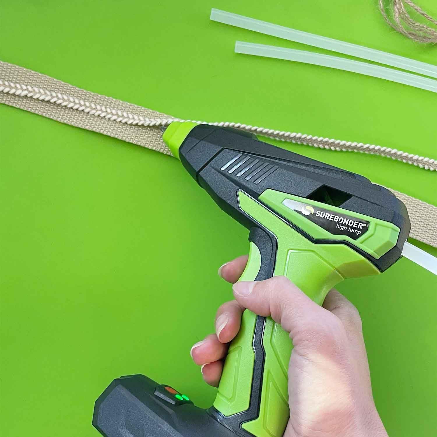 Hand applying hot glue with Surebonder glue gun