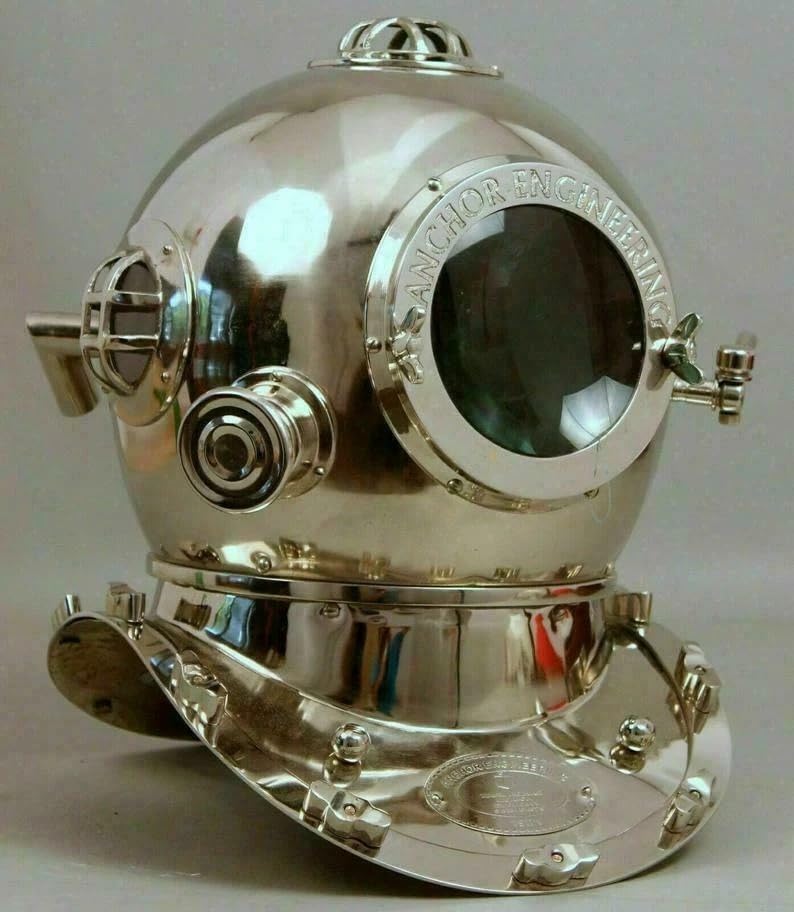Il casco inciso US Navy Mark V è un accento perfetto per qualsiasi stanza a tema nautico; la finitura rustica in rame lucido aggiunge un tocco glorioso che non si trova in tutte le repliche di caschi subacquei