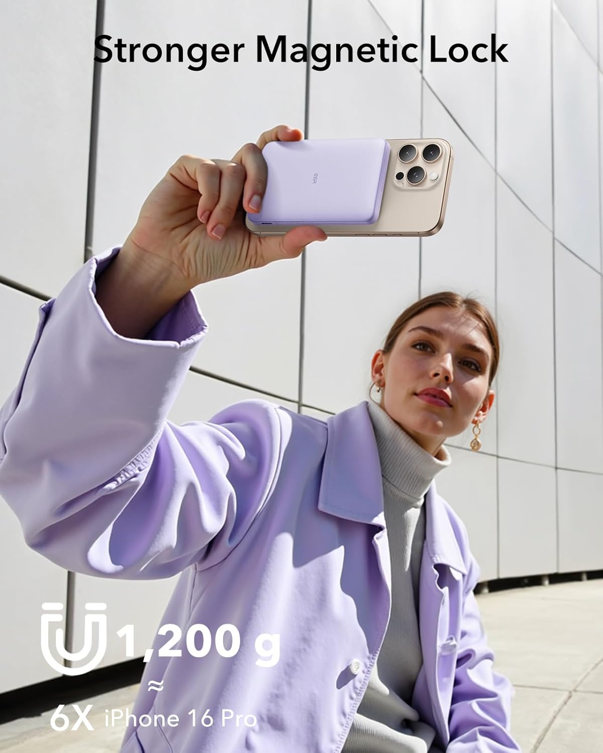 A woman holding an iPhone with the ESR MagSafe Power Bank attached, demonstrating the strong magnetic lock.