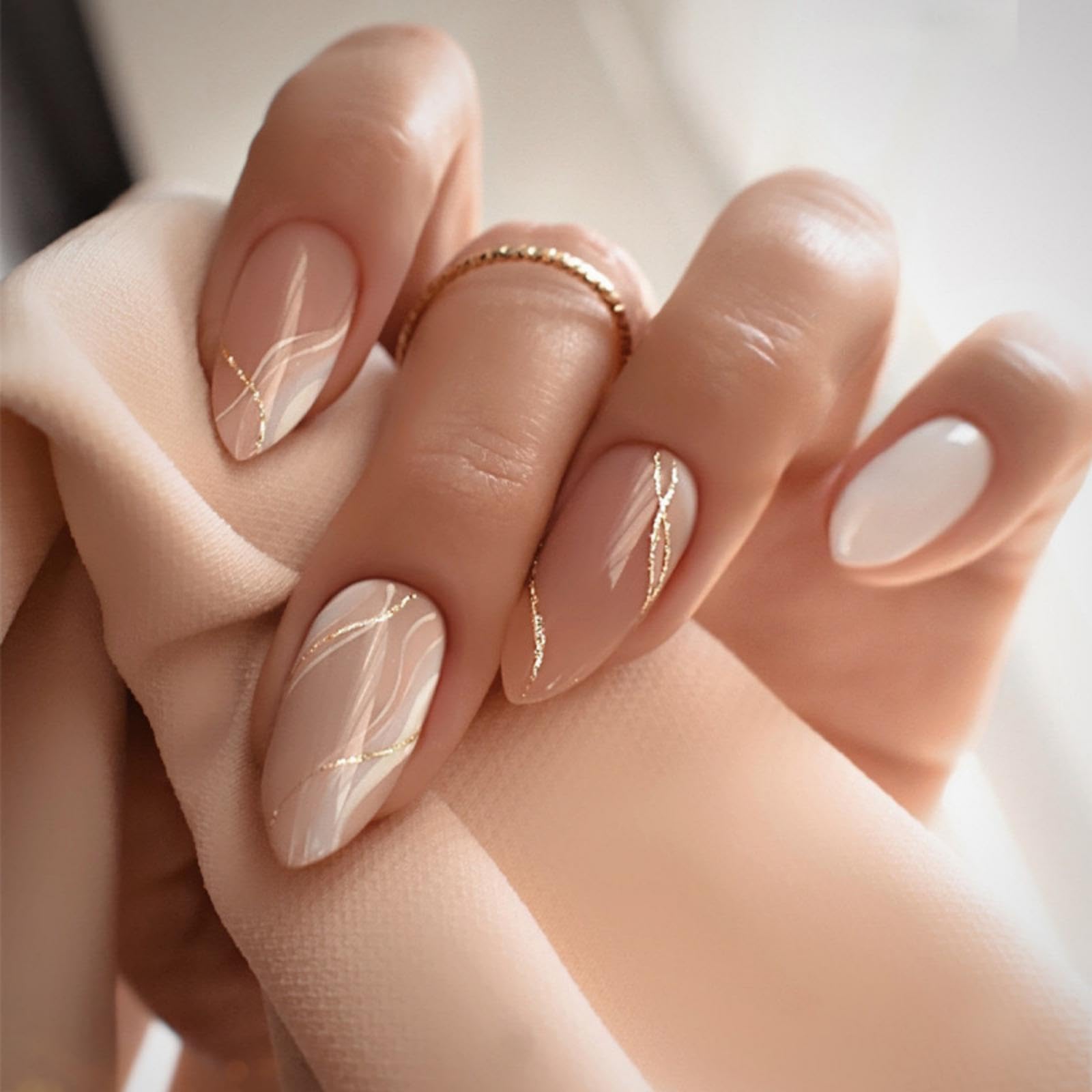 Nude almond nails with soft marble veining and gold line accents