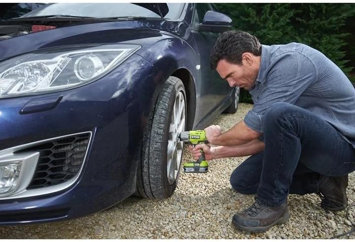 Man using Ryobi Impact Wrench to remove a car wheel lug nut