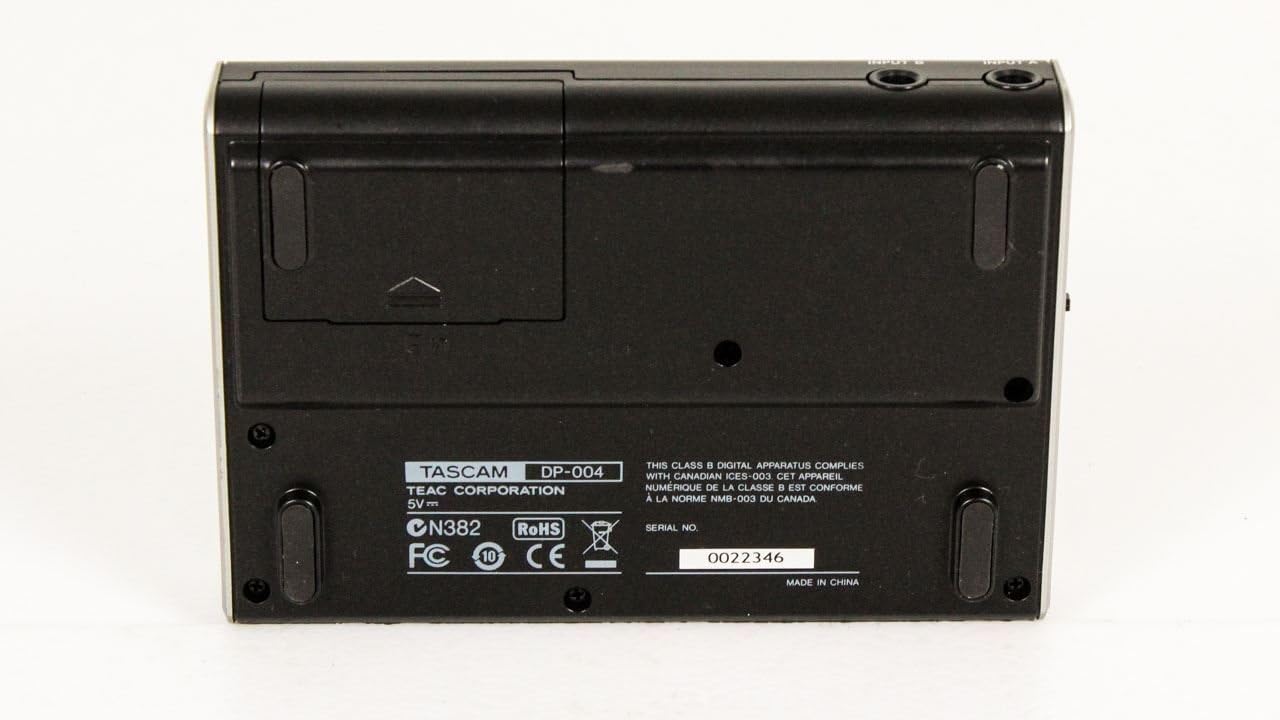Bottom view of Tascam DP-004 showing battery compartment and product labels