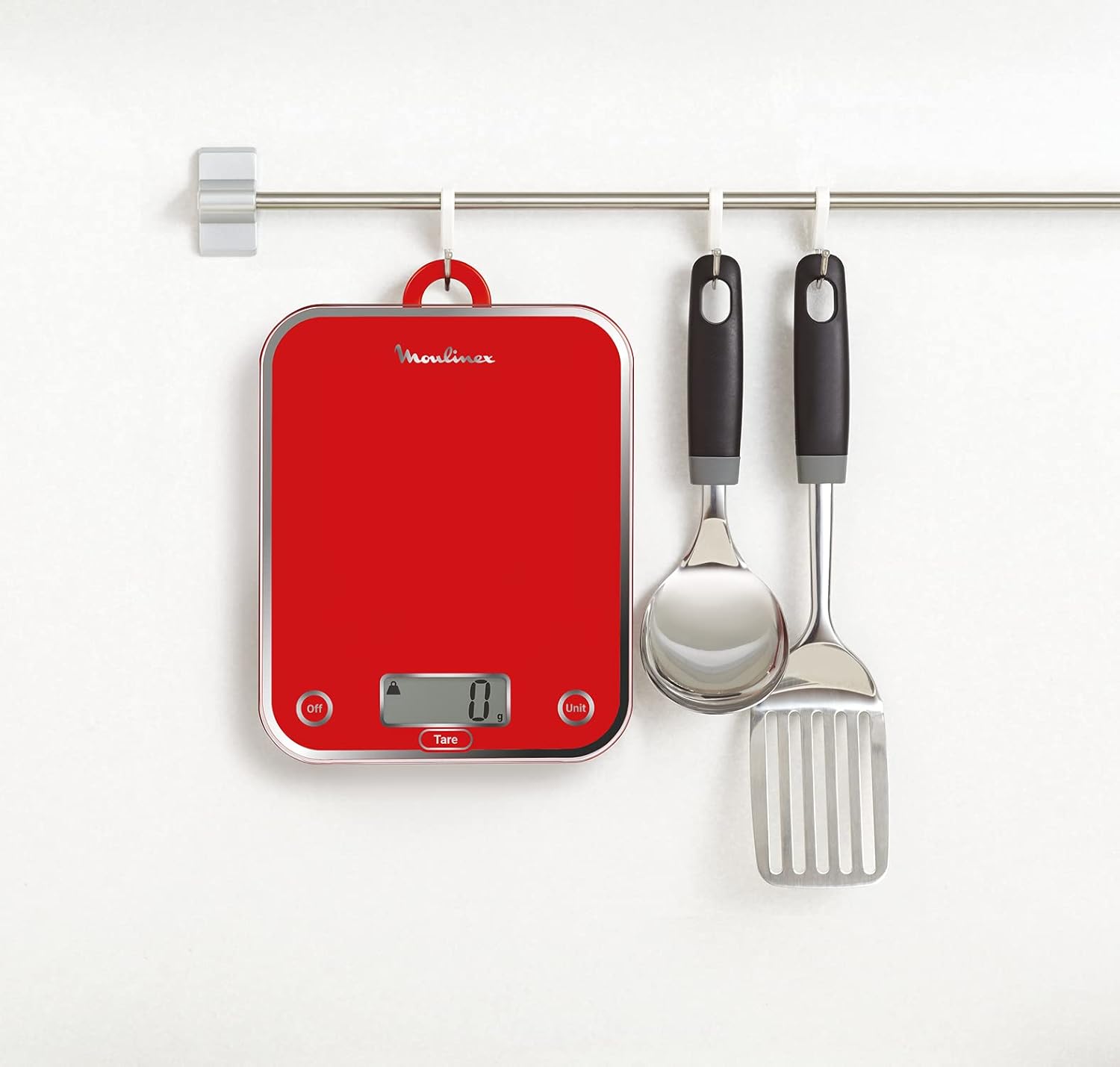 Moulinex Optiss BN5003 kitchen scale hanging on a kitchen rail next to other utensils, demonstrating its compact storage.