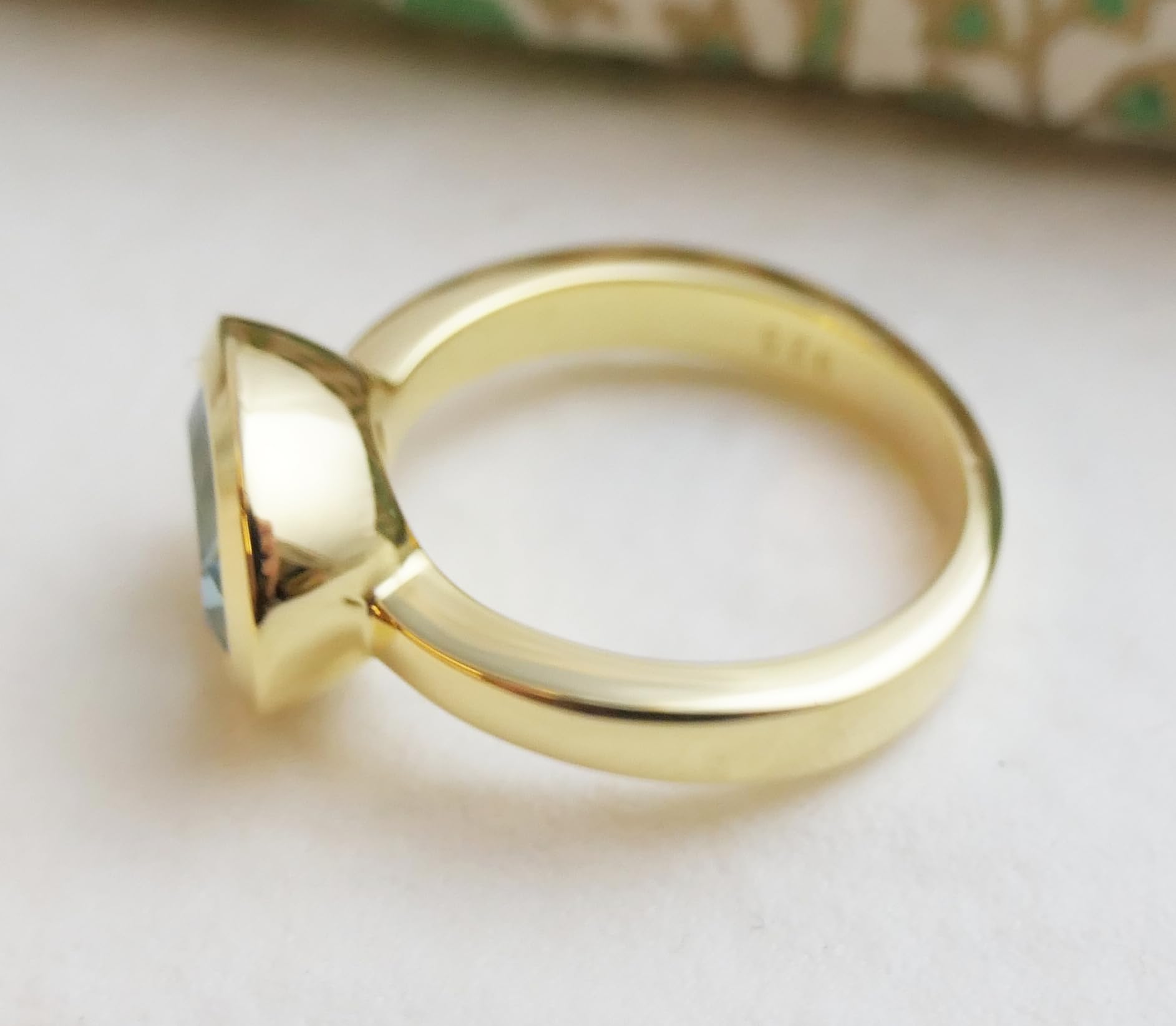 Anillo ovalado de plata de ley con baño de oro y topacio azul