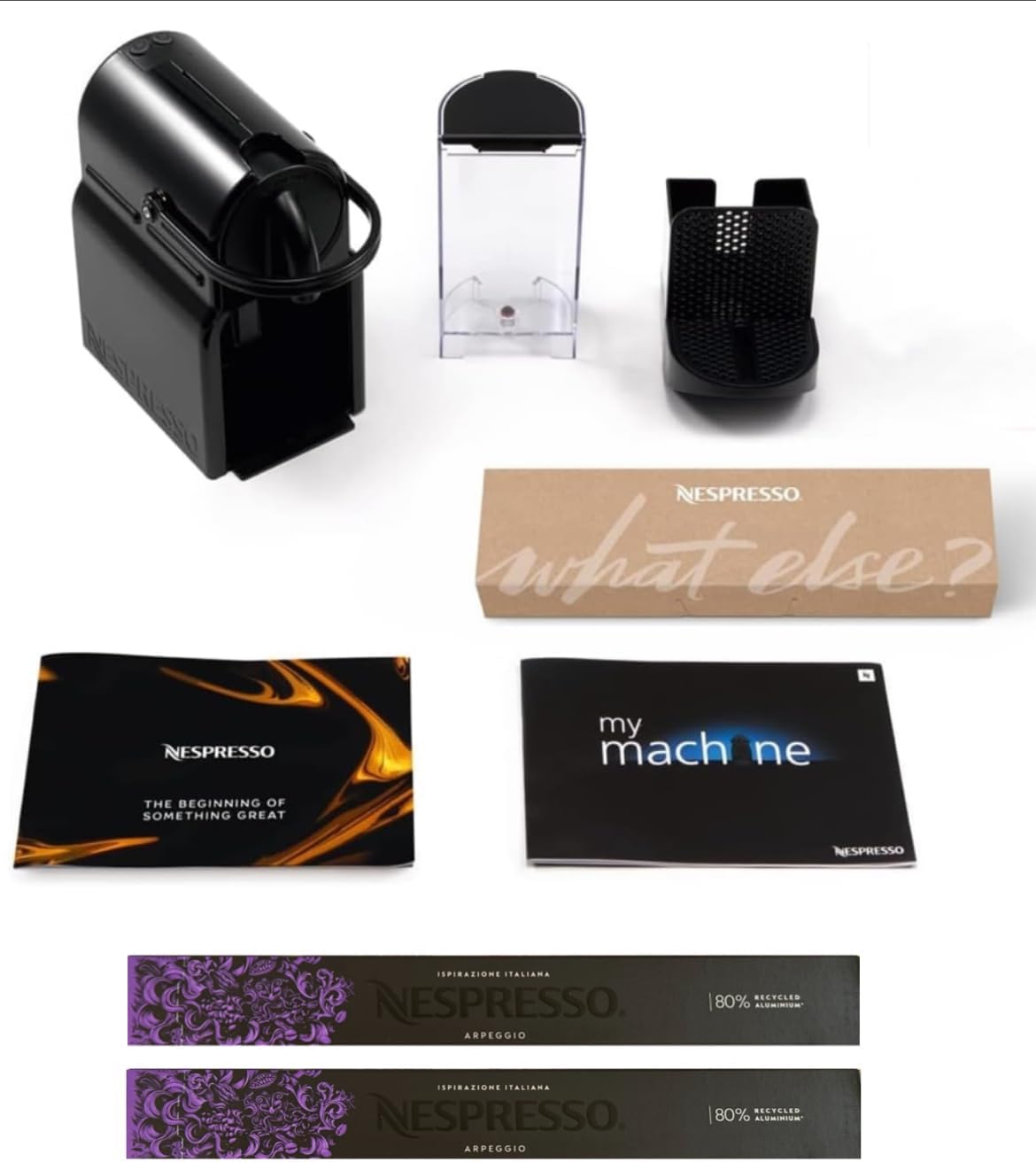 Unboxed Nespresso Inissia components including machine, water tank, and manuals