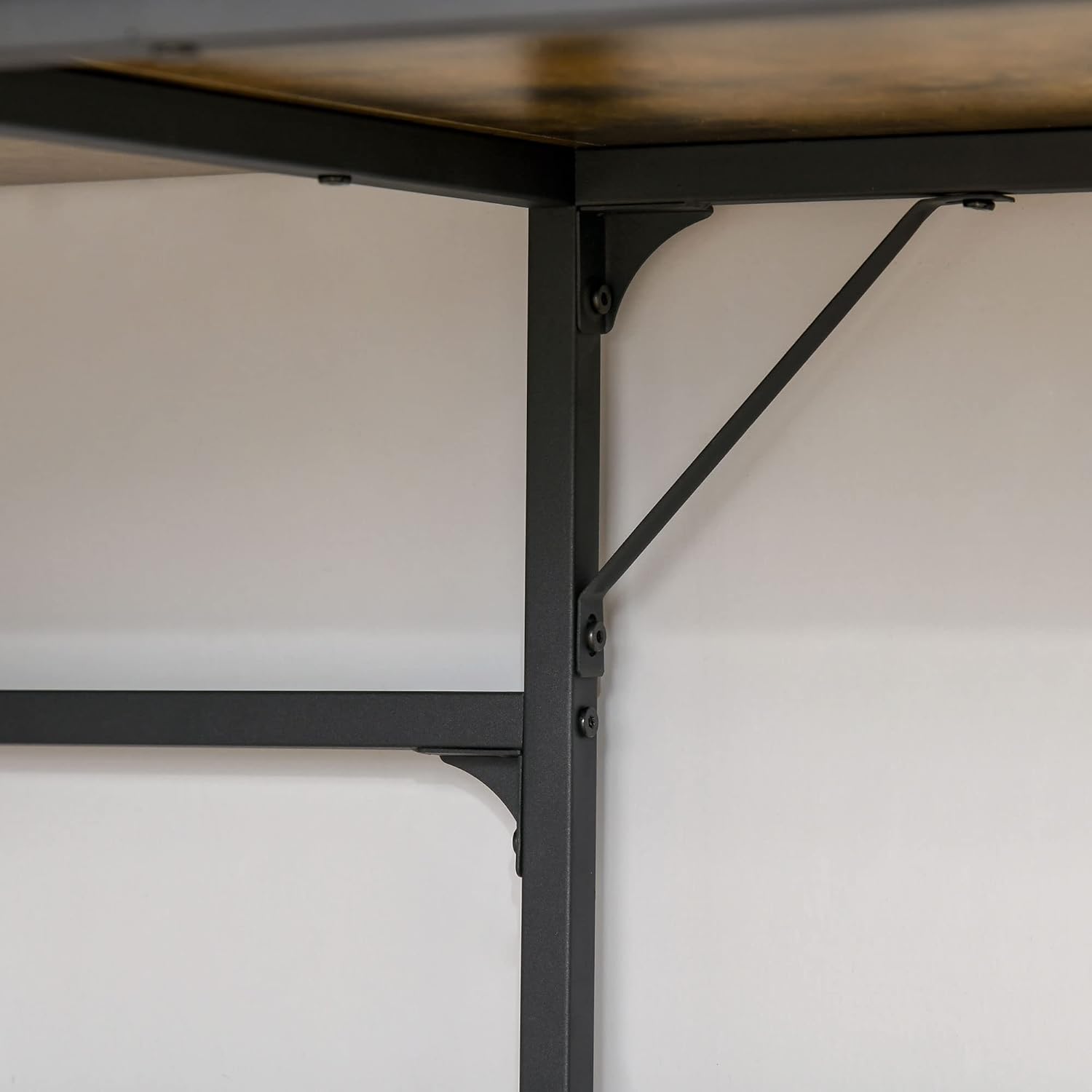 Close-up of the black metal frame and support bracket, highlighting the desk's robust construction.