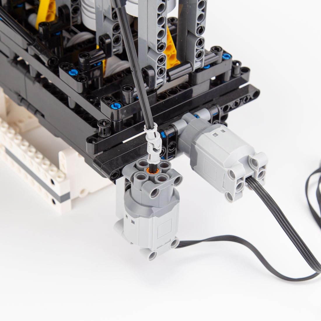 Close-up of the motor connection point on the DiyXenginey Inline 6 Cylinder L6 Engine model, showing a black cable connected to a gray block.