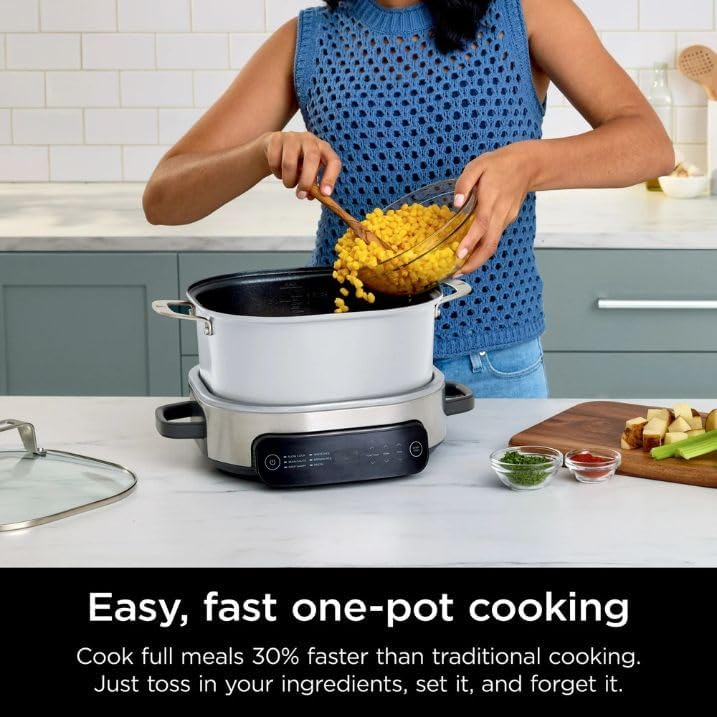 A person adding corn to the PossibleCooker, demonstrating easy one-pot cooking.