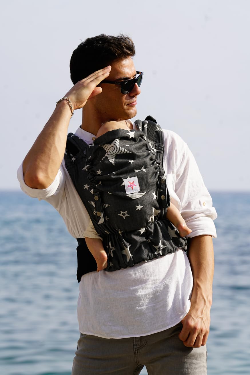 KOKADI Flip X Diorite Stars (Unisize)-Perfekte Kombi aus Fullbuckle & dem Tragen überkreuzt -Ab Geburt - 15 kg,handgefertigt aus 100%Bio-Baumwolle –Ergonomische Babybauchtrage Rückentrage Tragetasche