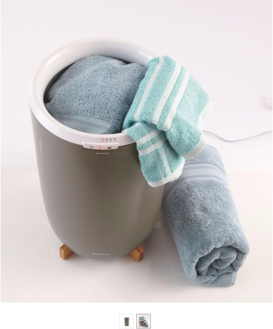 Brookstone Towel Warmer with two light blue towels, one inside and one rolled next to it.