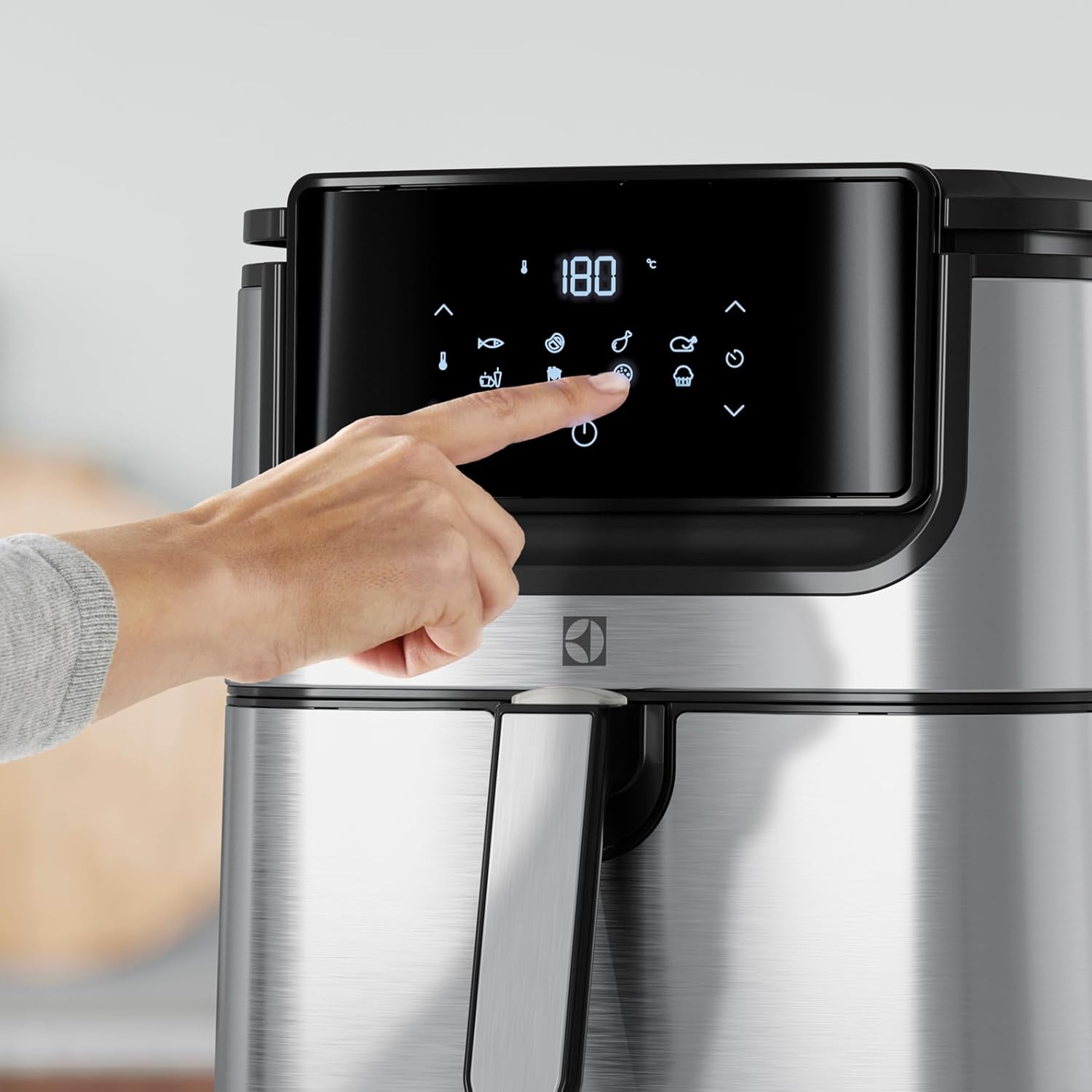 User interacting with Electrolux Air Fryer touchscreen